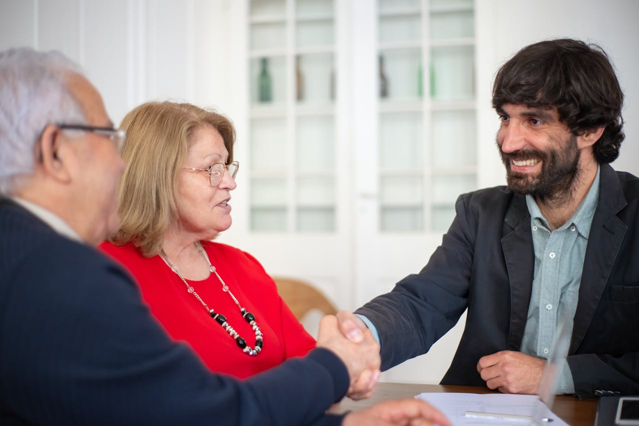 Business professionals engaged in a positive office meeting, sealing a deal with a handshake.